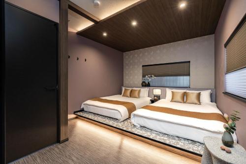 a bedroom with two beds and a window at JAPAVISTA Hinata in Osaka