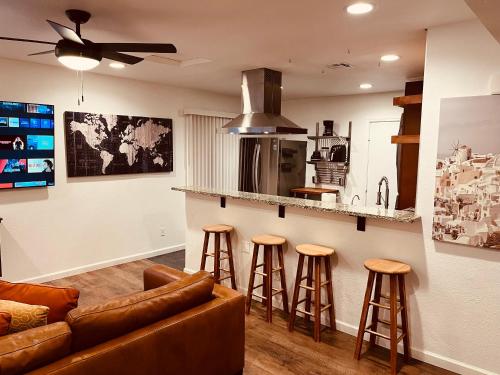 a living room with a couch and bar with stools at Cozy 2-BR Retreat in Kingman, AZ in Kingman