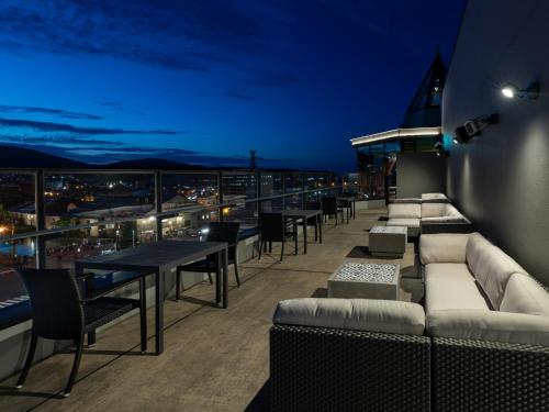 a rooftop patio with tables and couches at night at Granbell Hotel Otaru in Otaru