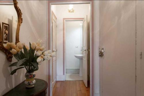 a bathroom with a vase of flowers on a table at Château Stay – 1BR 4P with Pool & Park Access in Fajolles