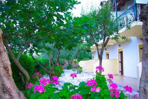 a garden with pink flowers in front of a building at Gerakari Thalassa Studios in Kypseli