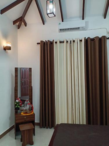 a bedroom with brown curtains and a table with a mirror at Pacifier Residence in Kandy