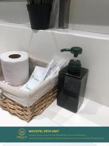 a soap dispenser and a roll of toilet paper at Novotel Twin Bed at Mandaluyong Near Makati FREE pool in Manila