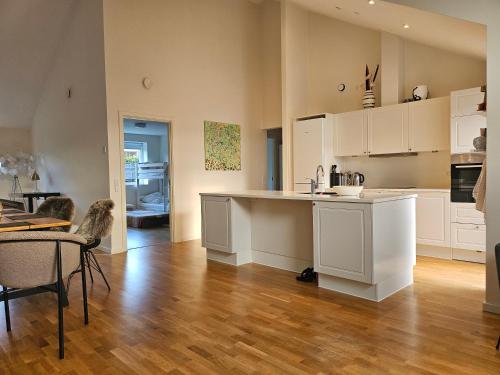 een keuken met witte kasten en een houten vloer bij Fam house in Malling