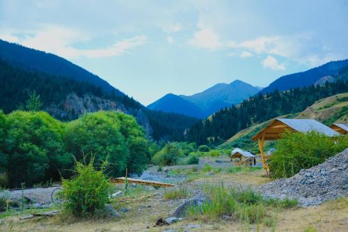a cabin in a valley with mountains in the background at Отдых в комфортабельных юртах в зоне отдыха Kolsay resort! in Kurmenty