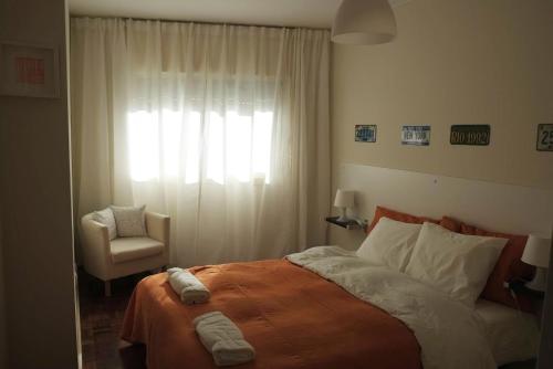 1 dormitorio con 1 cama, 1 silla y 1 ventana en Porto 2 Bedroom Beach Apartment, en Matosinhos