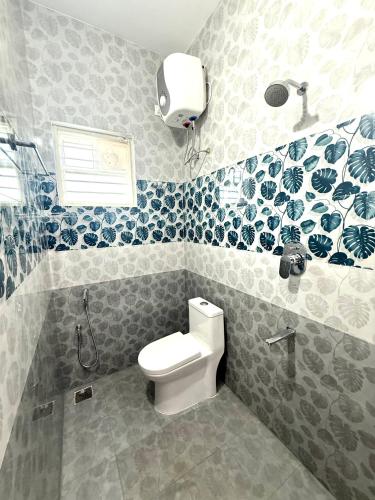 a bathroom with a toilet and a shower at Q by Kolam - Women and Family Serviced Apartments, Thoraipakkam, OMR in Chennai