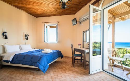 a bedroom with a bed and a desk and a balcony at Villa Eliza in Skala