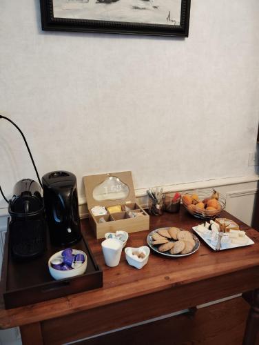 a table with plates of food and a coffee maker at La Maison d'Adèle in Neufchâteau