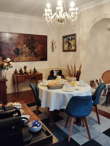 a dining room with a table and a chandelier at La Maison d'Adèle in Neufchâteau