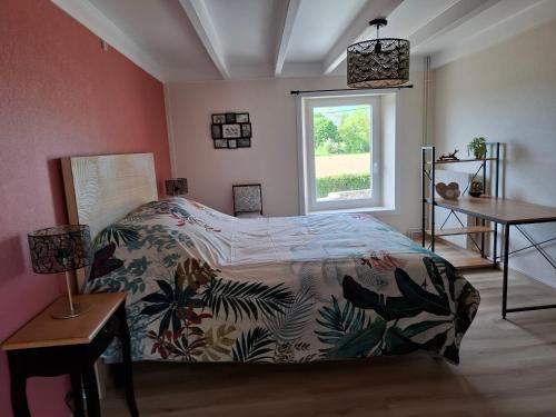 une chambre avec un lit et une fenêtre dans l'établissement Les Campanules, à Sainte-Geneviève