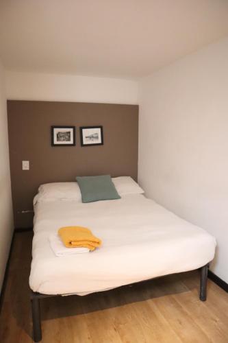 a bed with white sheets and a green towel on it at Habitación privada en Polanco cerca del Metro in Mexico City
