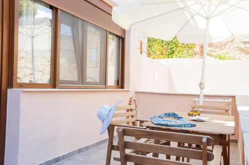 a table and chairs with an umbrella on a patio at Villa Fun & Sun in Limenaria