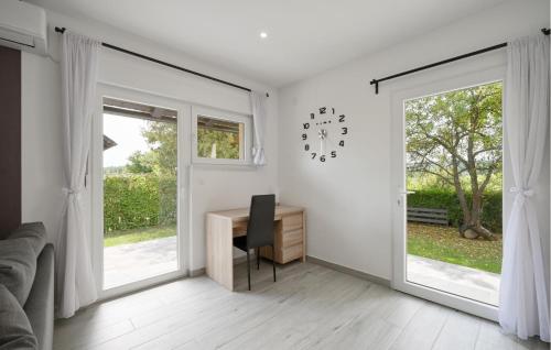 a white room with a desk and a clock on the wall at 2 Bedroom Cozy Home In Duga Resa in Duga Resa