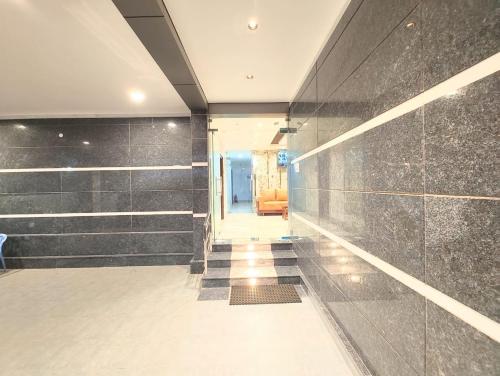 a room with a hallway with black tile walls at MG Park in Chennai