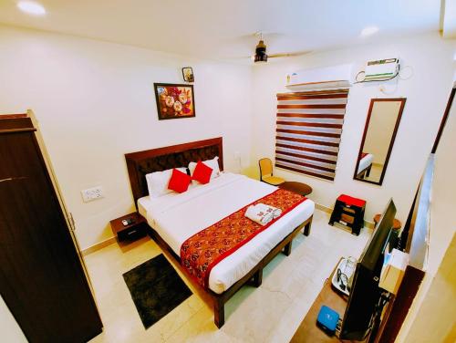 a bedroom with a large bed with red pillows at MG Park in Chennai