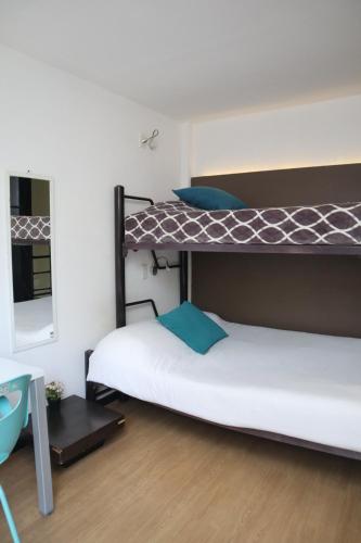 two bunk beds in a room with a mirror at Hermosa Habitación con balcon cama mat y litera Polanco in Mexico City
