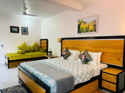 a bedroom with a bed and a couch at Vedant Valley Resort, Kund-Guptkashi, By Himalayan Eco Lodges in Rudraprayāg