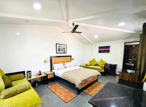 a hotel room with a bed and a couch at Vedant Valley Resort, Kund-Guptkashi, By Himalayan Eco Lodges in Rudraprayāg