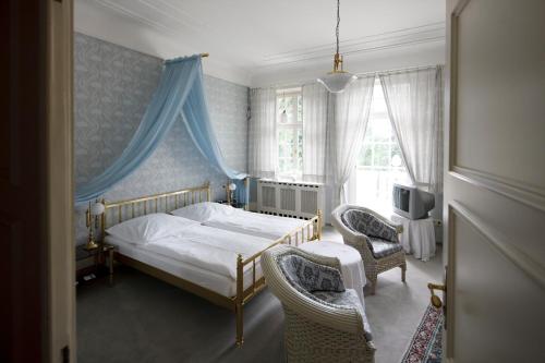 a bedroom with a bed and two chairs at Hotel Park Villa in Heilbronn