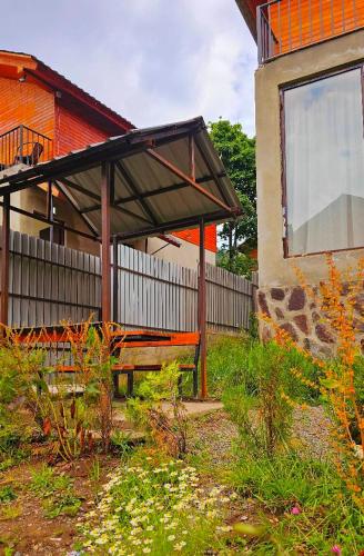 a bench in a yard next to a building at Cottage by the Forest in Bakuriani