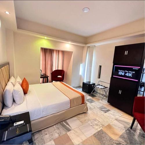 a hotel room with a bed and a flat screen tv at The Elite Residence Dhaka in Dhaka