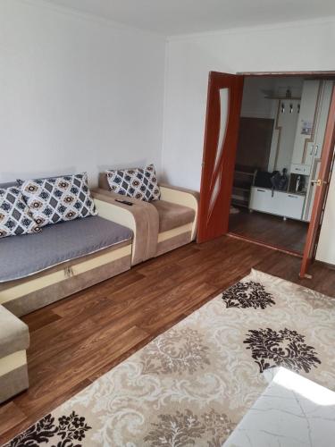 a living room with a couch and a mirror at Комфортная квартира для гостей города in Qyzylorda