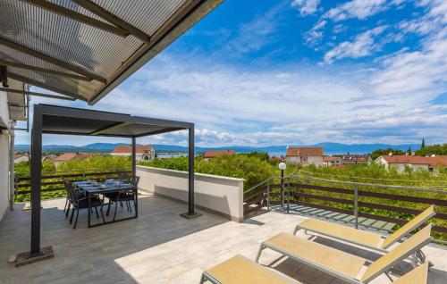 a patio with a table and chairs on a balcony at 3 Bedroom Cozy Apartment In Malinska in Malinska
