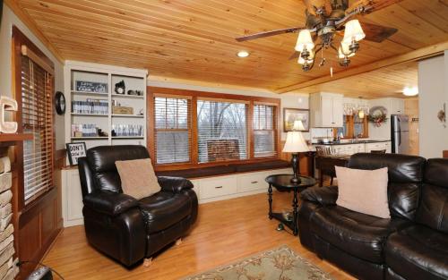 a living room with leather furniture and a kitchen at Karens Cozy Cottage in Gatlinburg