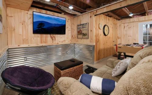 a living room with wooden walls and a pool table at Karens Cozy Cottage in Gatlinburg