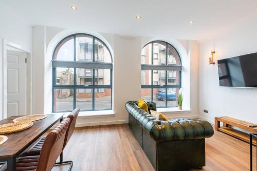 a living room with a couch and a table and windows at Bissets Bond in Dundee