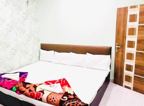 a bedroom with a bed with white sheets at Hotel Aliza Palace Ajmer AC OR NON AC ROOM in Ajmer