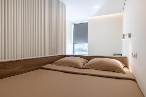 a bed in a room with a window at Urban Nest by Arena and Stadium in Kaunas