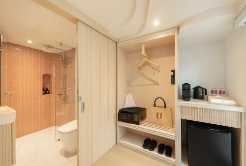 a bathroom with a shower and a toilet and a television at U Hua Hin in Cha Am