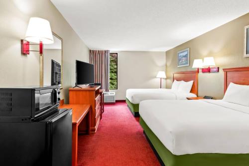 a hotel room with two beds and a flat screen tv at Econo Lodge Mt Hope - Beckley in Mount Hope