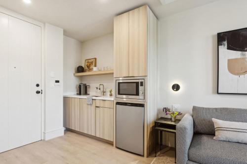 a small kitchen with a couch and a microwave at Casa Riviera - Boutique Apartments in Downtown Santa Barbara in Santa Barbara