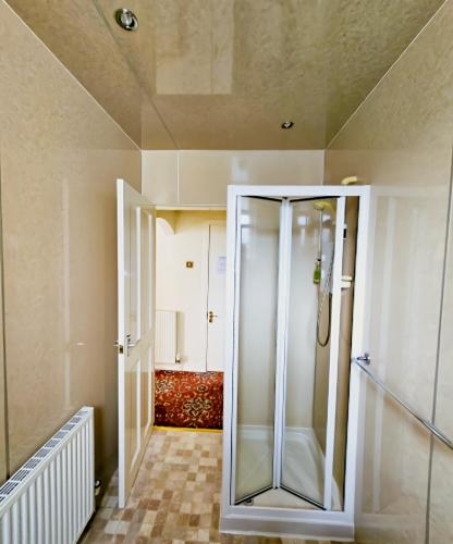 a walk in shower in a bathroom with a glass door at Station Hotel Portsoy in Portsoy