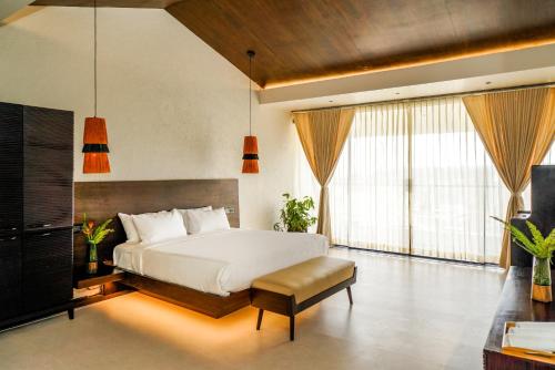 a bedroom with a white bed and a large window at Virgin Valley Leisure Resort in Ooty