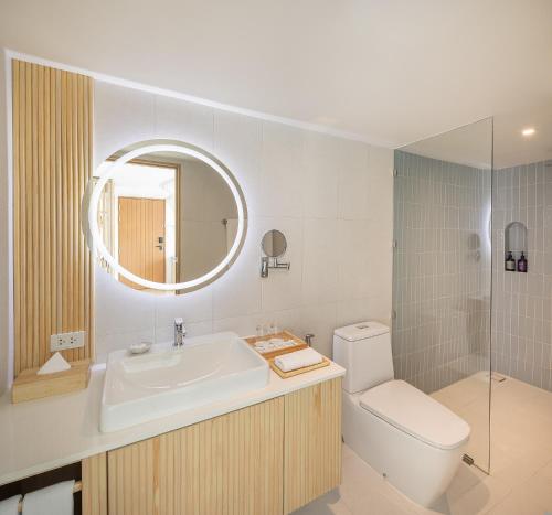 a bathroom with a sink and a toilet and a mirror at U Hua Hin in Cha Am