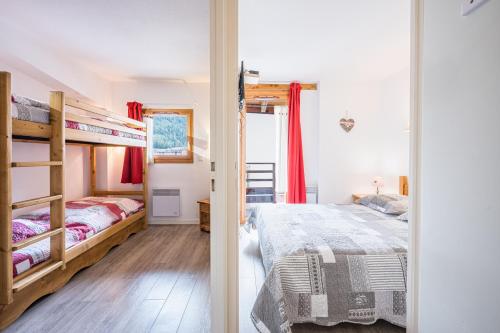 a bedroom with two bunk beds and red curtains at Les chalets de la vanoise n°4208 in Villarodin-Bourget