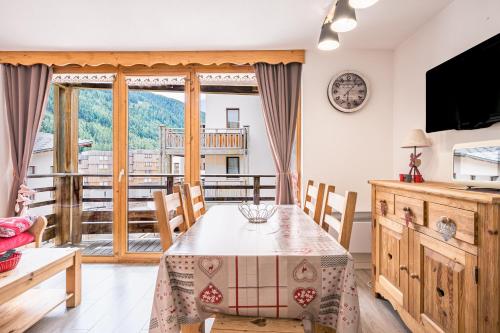 une salle à manger avec une table et un balcon dans l'établissement Les chalets de la vanoise n°4208, à Villarodin-Bourget