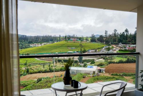 a window with a table and a view of a field at Virgin Valley Leisure Resort in Ooty