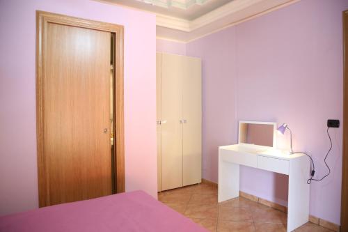 a bedroom with a bed and a desk and a door at Villa Manno in Barcellona-Pozzo di Gotto