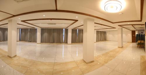 a large room with a large hall with columns and a ceiling at ROOTS A Unit of Coastal Dine Restaurant & Lodging in Bengaluru