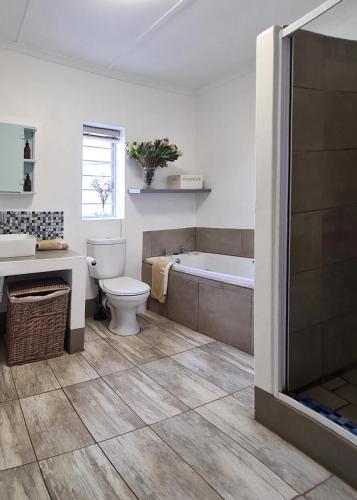 a bathroom with a tub and a toilet and a sink at Plaas Wegbreek in Barrydale