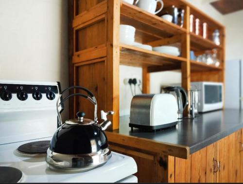 a tea kettle sitting on top of a stove in a kitchen at Plaas Wegbreek in Barrydale