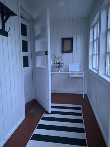 a hallway with a white door and a black and white rug at Huoneisto Petsamossa in Tampere