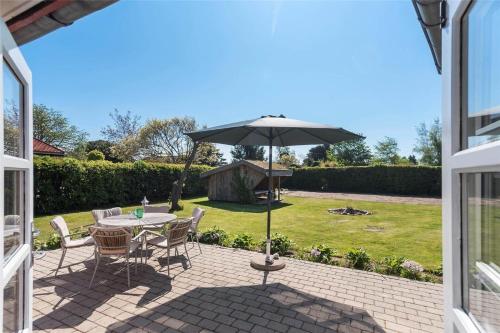 a patio with a table and an umbrella at R624-Rodvig-Stevns-Strandvaenget-6 in Rødvig