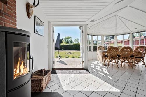 a fireplace in a living room with a table and chairs at R624-Rodvig-Stevns-Strandvaenget-6 in Rødvig