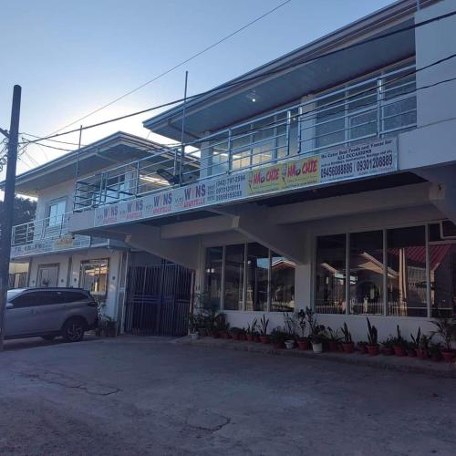 a building with a car parked in front of it at RedDoorz at Wyns Hotel in Silañgang Mayao